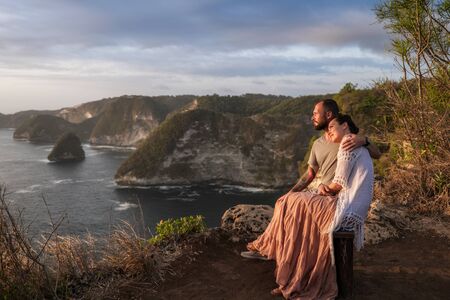 Couple enjoying view from Banah Cliff of Nusa Penida island, Indonesiaの写真素材