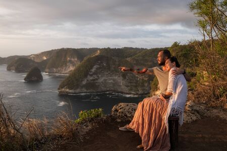 Couple enjoying view from Banah Cliff of Nusa Penida island, Indonesiaの写真素材
