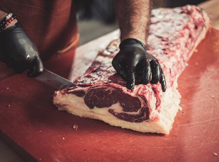 Chef cutting beef steakes in a restaurantの写真素材