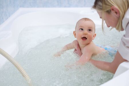 Baby boy getting an aquatic massageの写真素材