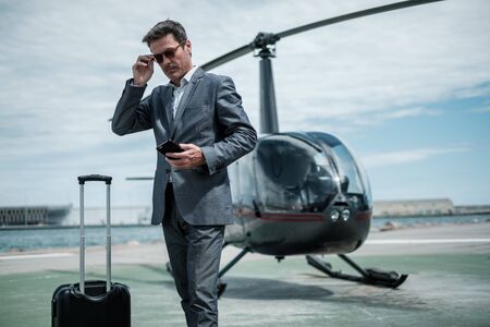 Businessman standing near private helicopterの写真素材