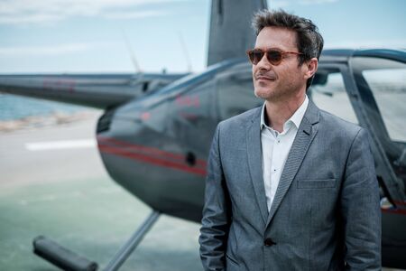 Businessman standing near private helicopterの写真素材