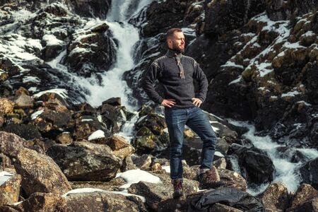 Man in front of Latefossen waterfall in winter, Norwayの写真素材