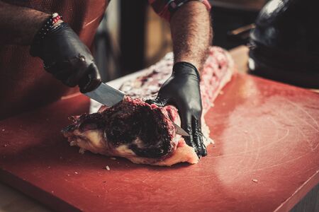 Chef cutting beef steakes in a restaurantの写真素材
