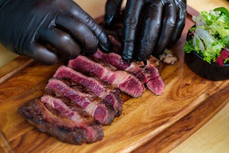 Serving freshly cooked beef steak on a wooden board