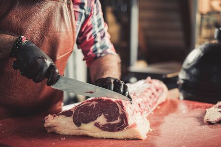 Chef cutting beef steakes in a restaurantの写真素材