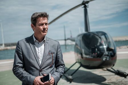 Businessman standing near private helicopterの写真素材