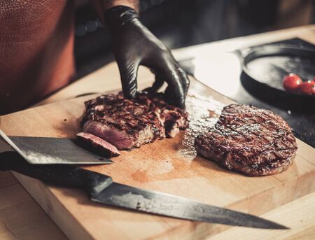 Chef serving freshly cooked meat in a restaurant.の写真素材