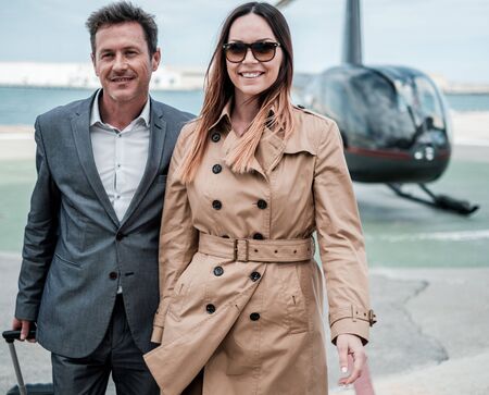 Young business couple near private helicopterの写真素材