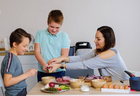 Happy family cooking togehter at homeの写真素材