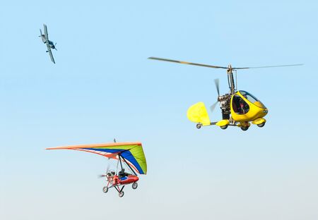 Airplain deltaplan and helicopter at air show on the blue skyの写真素材