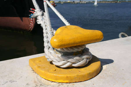 Yellow mooring hook with ship rope in the harborの写真素材