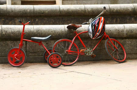 Two red retro bicycles and modern helmet