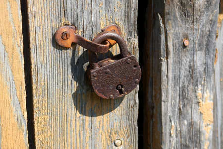 Old rusty padlock on the wooden doorの写真素材