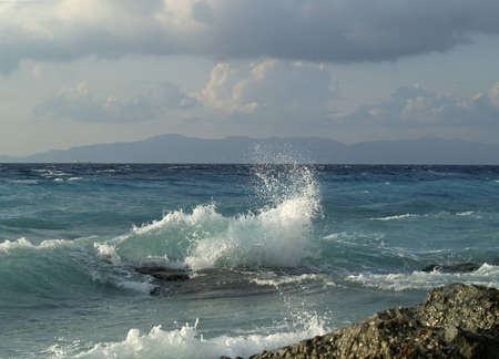 Wave breaking against stonesの写真素材