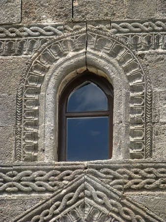 Window and stone wall with decorative stone carving. Lindos, Rhodes, Greeceの写真素材