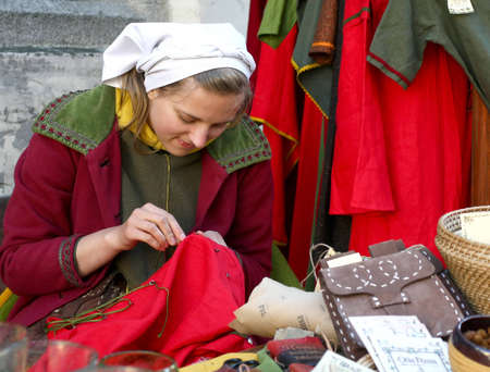 Tallinn, Estonia - June 5, 2010: A young girl in medieval clothes sells souvenirs. Tallinn Old Town Daysのeditorial素材