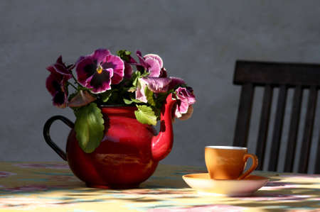 Teapot with flowers and cup on the table in an outdoor cafe. Tallinn, Estoniaの写真素材