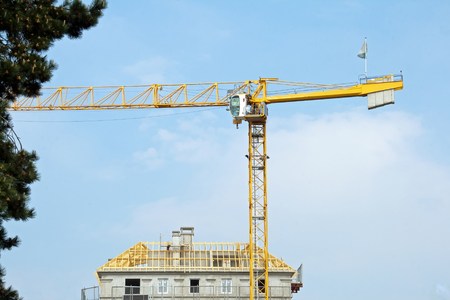 House under construction and yellow crane, roof under constructionの写真素材