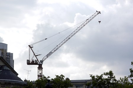 crane in the city against the light under threatening skiesの写真素材