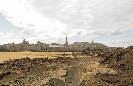 Cited of St Malo at low tide, under a cloudy sky (Brittany, France).のeditorial素材