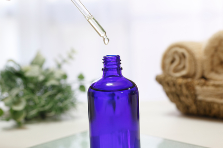 Pour oil into a bottle using a dropperの写真素材