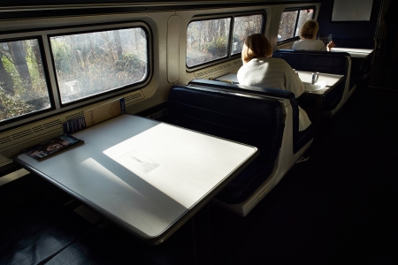 Adult train passangers reading at table while riding the East Coast Train between Boston and New York のeditorial素材