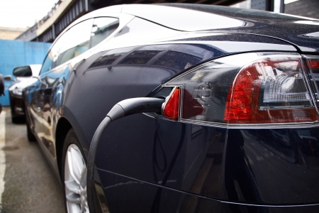 A Tesla Motors Model S charging at a public parking garage.のeditorial素材
