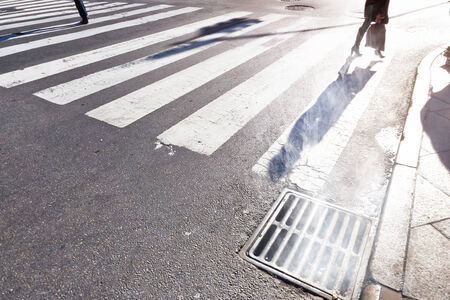 pedestrians cross zebra stripes in Manhattan on a cold but sunny winter dayの写真素材