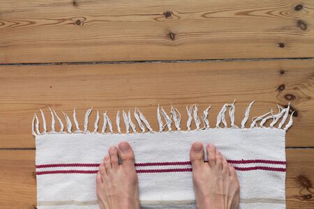 mans feet on white carpet and wooden floor