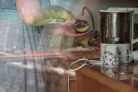 woman in kitchen cutting avocadoの写真素材