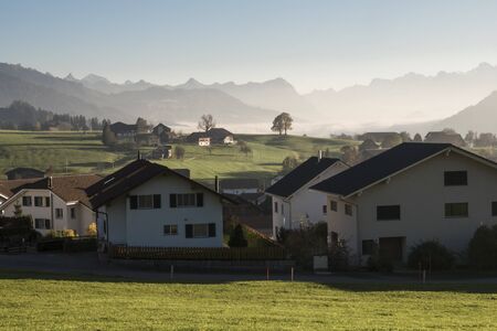 Swiss village dwellings and mountain silhouettes in the background.のeditorial素材