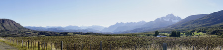 Torres del Paine National Park landscape panorama. An immaculate sky hangs over the breathtaking Andes and plant life below. A diverse landscape of grass, trees, water, and mountains. の写真素材
