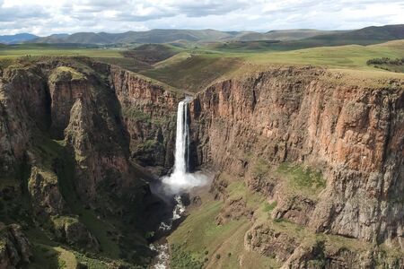 horizontal shot of stunning waterfall running down a steap canyon