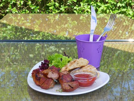 Pork meat on a plate with red sauce. Kebab. Juicy meat cooked on skewers. Delicious kebab skewer juicy pork and beef.の写真素材