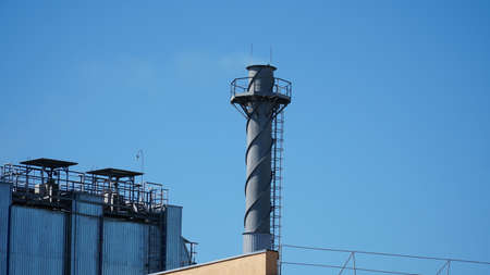 Smoking Chimneys. Factory chimneys with thick smoke against the background of sunset sky. chimney.の写真素材