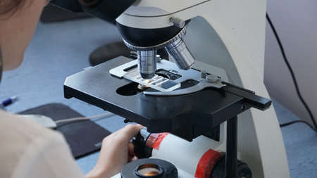 close-up of scientist hands with microscope, examining samples and liquidの写真素材