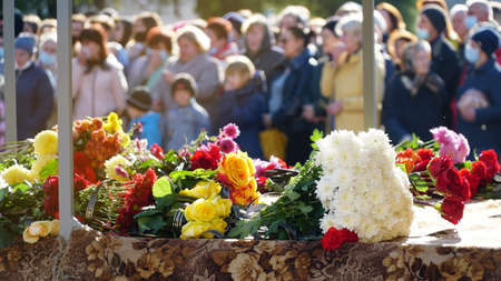 people and mourning concept - woman with white lily flowers and coffin at funeral in church. nの写真素材
