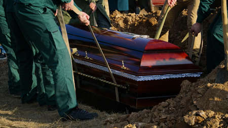 Religion, death and dolor - coffin bearer carrying casket at funeral to cemetery. nの写真素材
