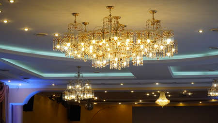 Luxurious crystal chandelier on the ceiling. bottom view. close-up. Huge crystal gold chandelier with candles. nの写真素材
