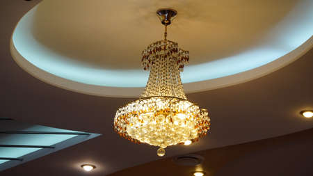 Luxurious crystal chandelier on the ceiling. bottom view. close-up. Huge crystal gold chandelier with candles. nの写真素材