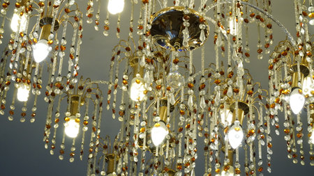 Luxurious crystal chandelier on the ceiling. Bottom view. Close-up. Huge crystal gold chandelier with candles.の写真素材