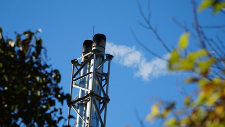 white smoke from the industrial pipe of the boiler room. Heating the house in winter. heating with woodの写真素材