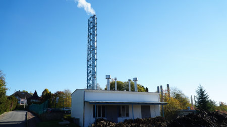 white smoke from pipe boiler room against background of blue sky. climate change concept. home heating.の写真素材