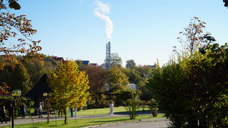 white smoke from pipe boiler room against background of blue sky. climate change concept. home heating.の写真素材