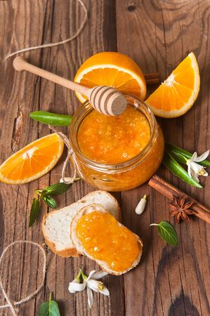 Orange, orange jam and bread on rustic wood backgroundの写真素材