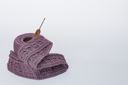 Knitting woolen scarf with needle and thread on a white backgroundの写真素材