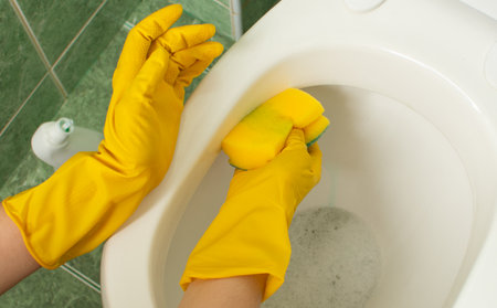 toilet cleaning,yellow cleaning gloves, handsの写真素材