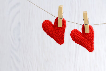 Two love hearts hanging on wooden texture background, valentines day card concept