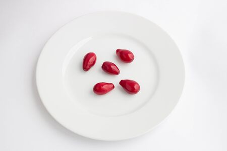 Dogwood berries on a plate on a white backgroundの写真素材